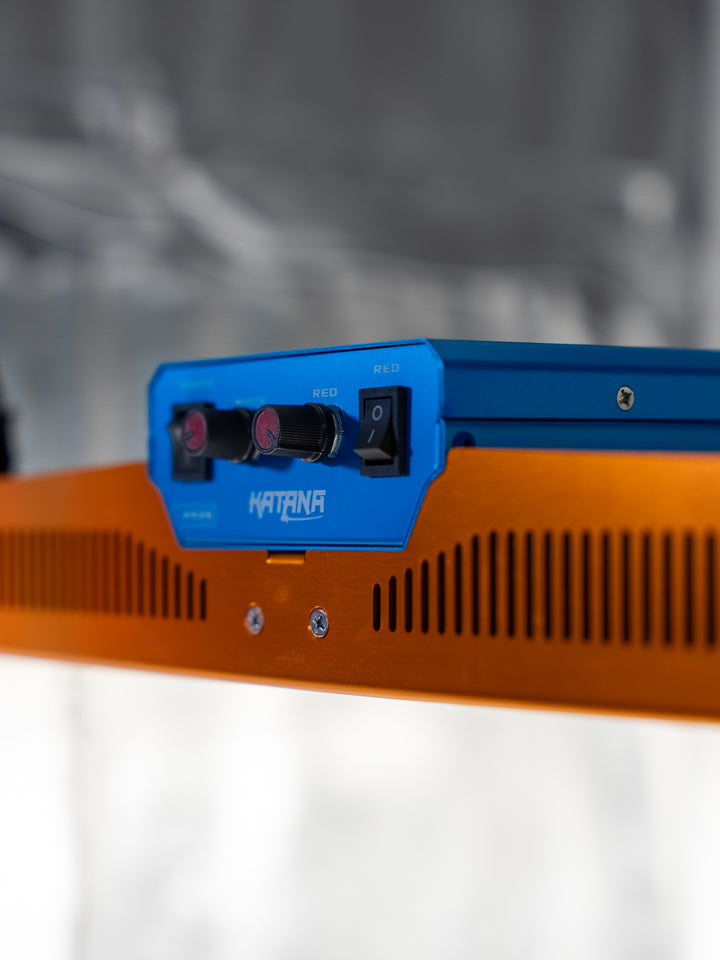 Orange and blue LED electronic device with 'Katana' branding on a blurred background